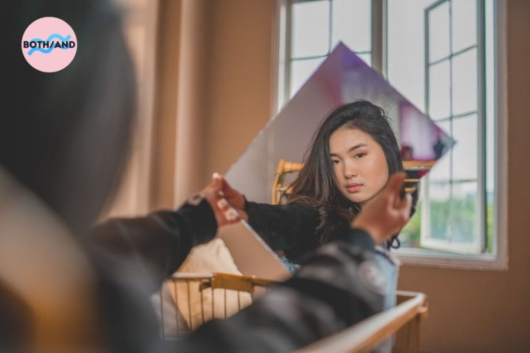 Woman holding a square mirror with her reflection