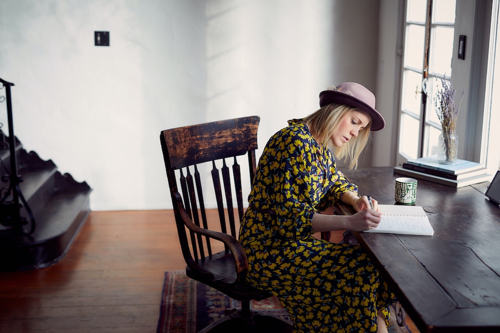 A woman writing at a wooden desk