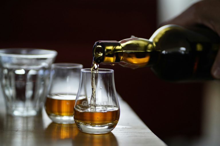 A person pours a glass of whiskey